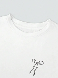 Détail d'un t-shirt en coton blanc avec imprimé nœud noir au design minimaliste