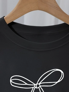 Nahaufnahme des Rippstrick-Rundhalsausschnitts und weißen Schleifendrucks auf schwarzem Shirt