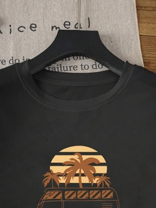 Detail view of cotton black T-shirt featuring vintage sunset palm tree van print