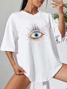 Detail of white oversized cotton t-shirt featuring golden evil eye graphic print