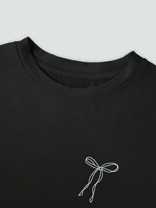 Détail du col rond et de l'imprimé nœud blanc sur un t-shirt décontracté noir pour femme