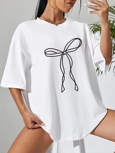 Dettaglio di una maglietta bianca oversize con una stampa a fiocco nero minimalista