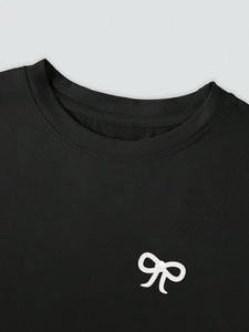 Nahaufnahme eines schwarzen Rundhals-T-Shirts mit weißem Schleifendruck und feinen Nähten