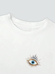 Nahaufnahme eines weißen Baumwoll-T-Shirts mit blau-goldener Evil Eye Grafik im Detail