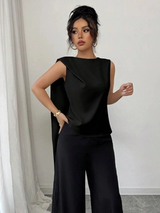 Elegant black sleeveless draped cape top paired with high-waisted wide-leg trousers