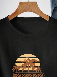 Black round neck t-shirt with tropical palm tree and sunset print on a wooden hanger