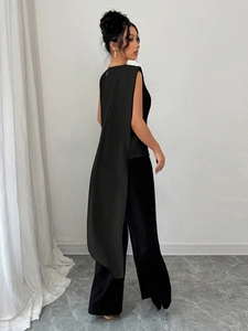 Detail view of women's black sleeveless top with long elegant drape and side slits