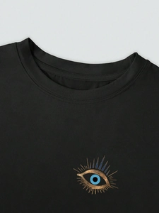 Detail von Rundhalsausschnitt und Evil-Eye-Print auf schwarzem Baumwoll-T-Shirt