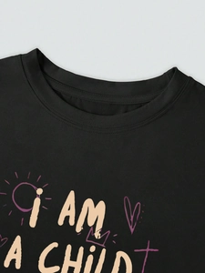 Detail of black cotton T-shirt featuring I AM A CHILD lettering and crown heart print
