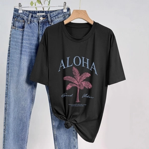 Dettaglio della t-shirt nera con stampa palma Aloha e nodo alla moda sull'orlo basso