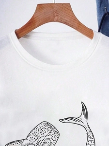 Close-up of minimalist whale print on a white cotton crew neck short sleeve t-shirt