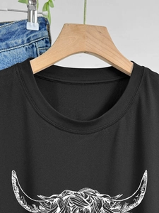 Primo piano di una t-shirt nera in cotone con una stampa grafica bianca artistica di corna