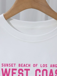 Detail of white cotton T-shirt featuring pink Sunset Beach Los Angeles graphic print