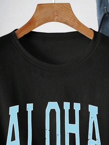 Détail du col rond à double couture et de l'imprimé ALOHA sur un t-shirt noir
