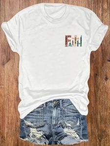 T-shirt in cotone bianco con stampa FAITH e pantaloncini di jeans logori su legno