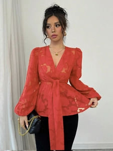 Detail of red lantern sleeves and floral jacquard texture on a sexy V-neck blouse