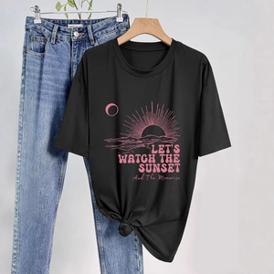 Dettaglio di t-shirt nera in cotone con stampa tramonto e nodo elegante sull'orlo
