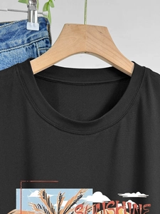 Détail d'un t-shirt noir en coton avec imprimé vintage SUNSHINE et col rond renforcé
