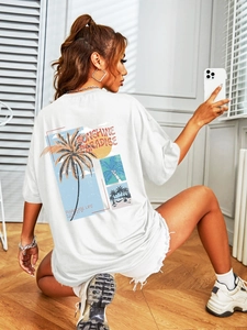 Close-up of oversized white t-shirt back with tropical SUNSHINE PARADISE print design
