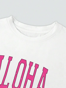 Detail von geripptem Rundhalsausschnitt und rosa ALOHA-Print auf weißem Baumwollshirt