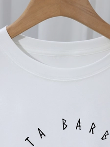 Close-up of white cotton T-shirt neckline with double-stitch and black TA BARB letter print
