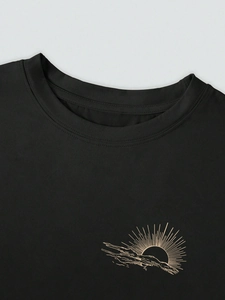 Gros plan d'un t-shirt noir à col rond avec imprimé soleil levant doré en coton de qualité