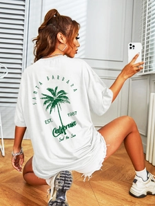 Detailed view of white oversized T-shirt featuring a green palm tree print on the back