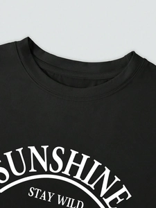 Détail du col rond renforcé et de l'imprimé blanc Sunshine Stay Wild sur t-shirt noir