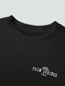 Detail of Palm Springs USA print on a black crew neck t-shirt with fine stitching