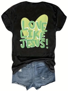 Détail de l'imprimé LOVE LIKE JESUS sur un T-shirt noir avec un short en jean