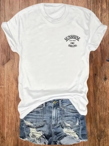 T-shirt blanc graphique Sunshine Stay Wild avec short en jean vieilli sur bois