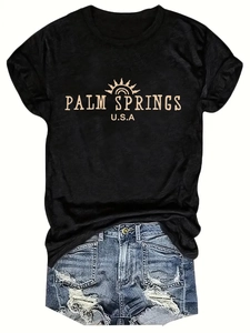 Detail of Palm Springs USA print on black cotton t-shirt with blue denim shorts