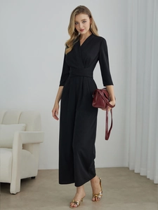 Detail view of black V-neck jumpsuit featuring elegant waist tie and wide leg silhouette