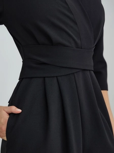 Detailed view of the elegant V-neck jumpsuit featuring waist pleats and side pockets