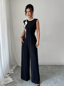 Combinaison noire élégante sans manches à jambes larges avec détail floral blanc