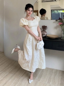 Détail de la robe jacquard crème élégante avec encolure carrée et manches bouffantes