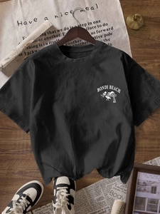 Women's black Bondi Beach graphic t-shirt in loose fit, flat lay on wooden floor