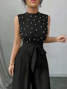Combinaison noire sans manches pour femme avec décorations de perles et ceinture noeud à la taille