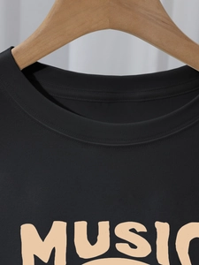 Detailed close-up of the round neckline and white MUSIC print on a black cotton T-shirt