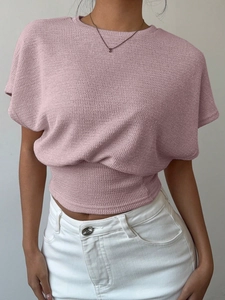 Détail de la maille gaufrée rose et de la taille froncée sur le haut à manches courtes