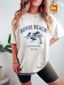 T-shirt blanc femme avec imprimé Bondi Beach porté avec un short de cycliste vert