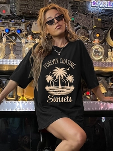 Women's black oversized cotton T-shirt featuring retro sunset beach and palm tree prints