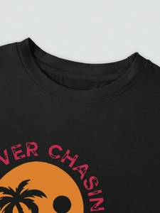 Detail of crew neck stitching and vintage sunset palm tree print on black cotton t-shirt