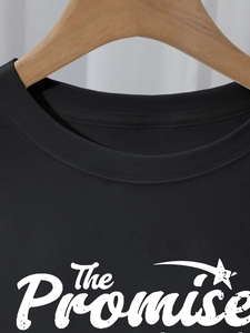 Detail of crew neck stitching and vintage The Promise print on black cotton t-shirt