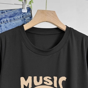 Gros plan du col de T-shirt noir avec impression MUSIC de style vintage sur la poitrine