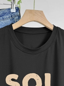 Women's black crewneck t-shirt with SOL letter print shown on a wooden hanger