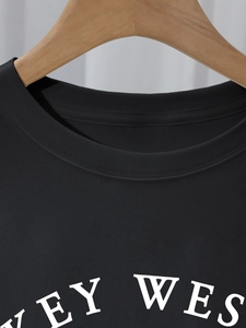 Close-up of crew neck stitching and Key West letter print on black cotton t-shirt