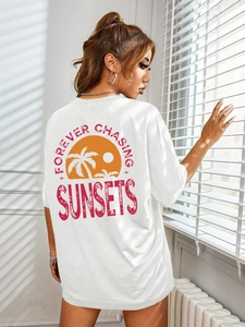Detail of white cotton T-shirt featuring a sunset palm tree graphic on the back