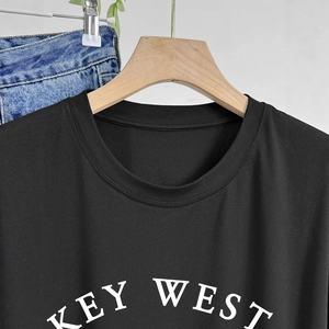 Detail of KEY WEST white lettering on a casual black cotton round neck short sleeve T-shirt