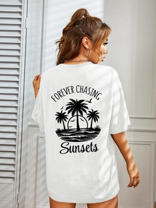 White oversized t-shirt with tropical sunset print and Forever Chasing Sunsets text on back